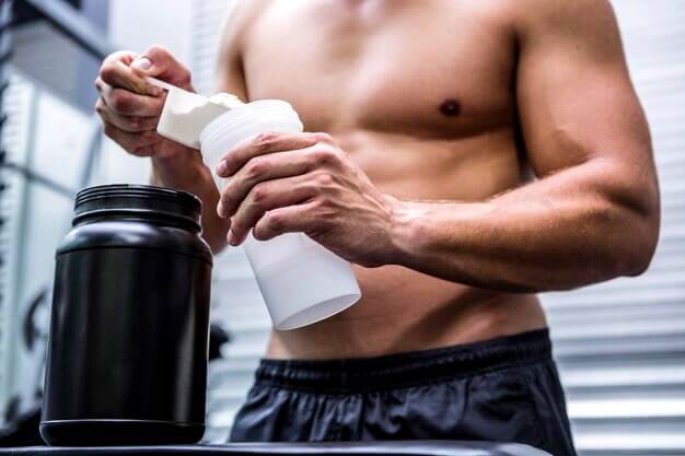 Homme musclé utilisant la whey (Protéine de lactosérum)